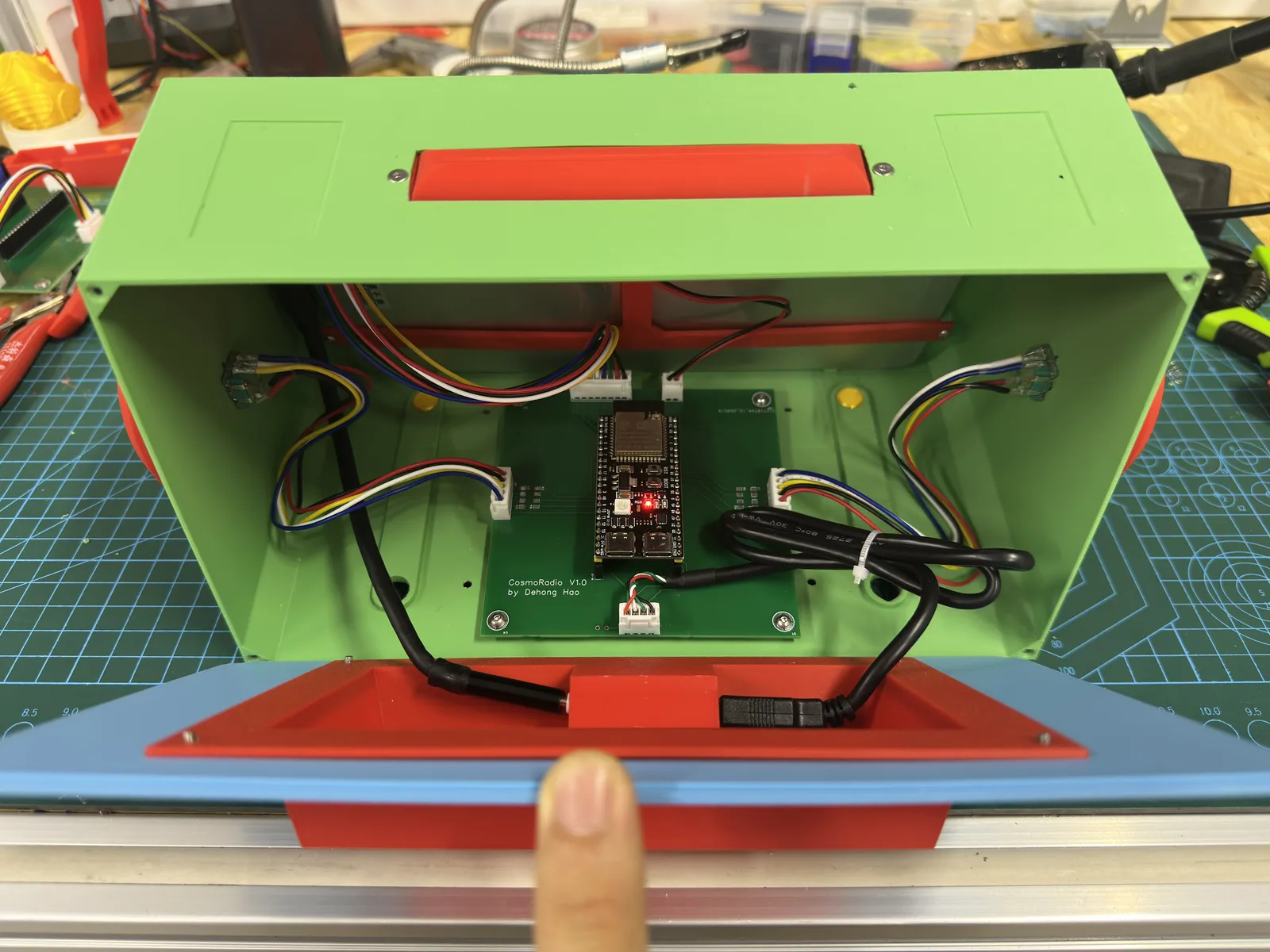 Inside a green printed case: a green circuit board marked CosmoRadio with wires running to knobs and a card reader